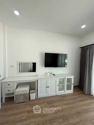 Modern living room with sleek TV setup and elegant white furniture