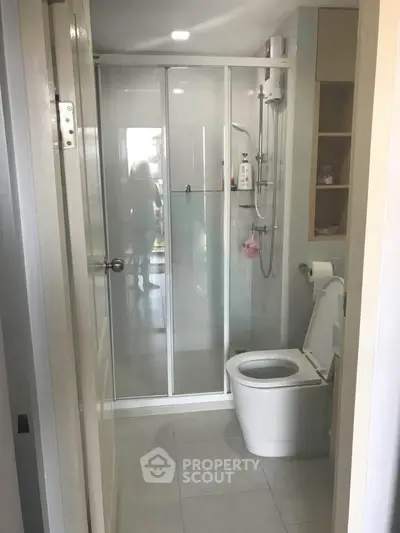 Modern bathroom with glass shower enclosure and sleek fixtures in a contemporary apartment.