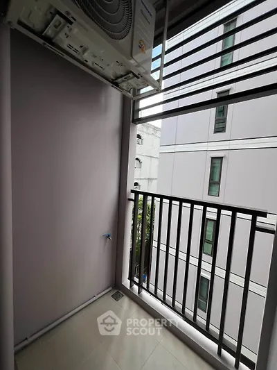 Modern apartment balcony with city view and air conditioning unit