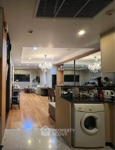 Spacious open-layout living room with modern decor and washing machine