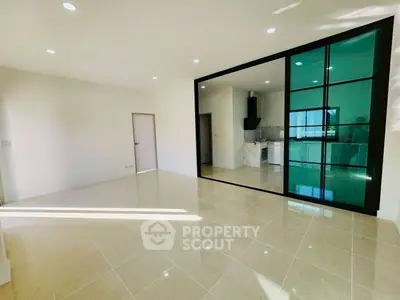 Spacious modern living room with glass partition and sleek kitchen