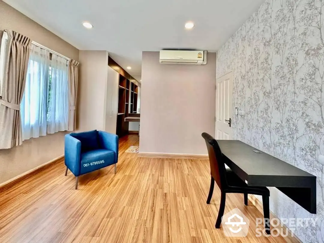 Spacious living room with elegant hardwood flooring, modern air conditioning, and stylish accent wall, perfect for comfortable urban living.