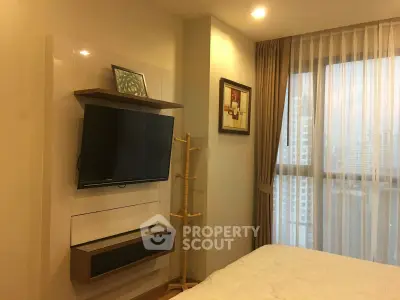 Modern bedroom with wall-mounted TV and large window offering city view