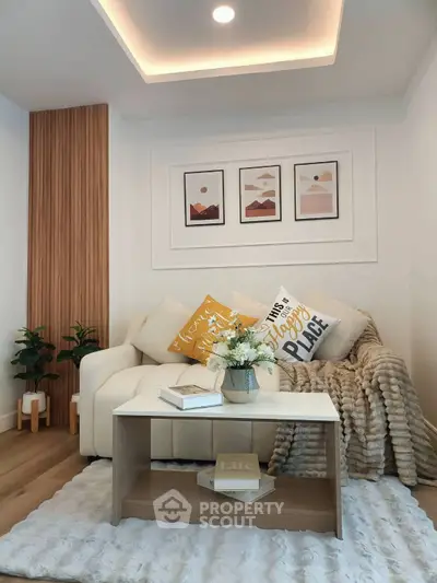 Cozy living room with modern decor, featuring a plush sofa, stylish coffee table, and elegant wall art.