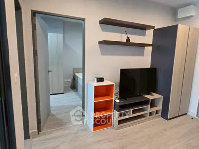 Modern living room with sleek furniture and open doorway to bedroom