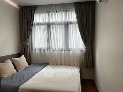 Cozy bedroom with elegant curtains and soft bedding in a serene setting.