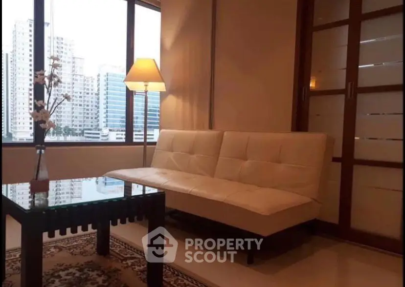 Cozy living room with city view, featuring a modern sofa and elegant decor.