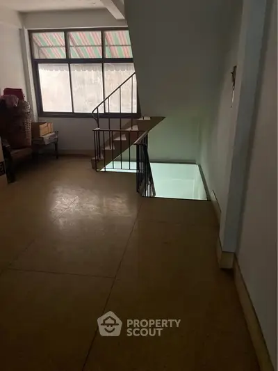 Spacious interior with staircase and large window, ideal for modern living.