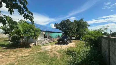 Charming rural property with blue-roofed house and spacious yard, perfect for countryside living.