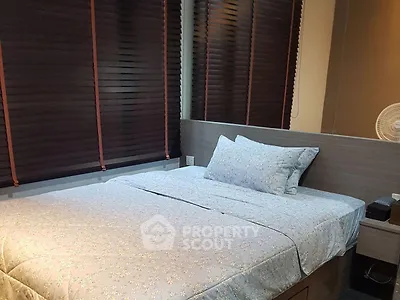 Cozy bedroom with modern blinds and comfortable bedding in a stylish apartment.