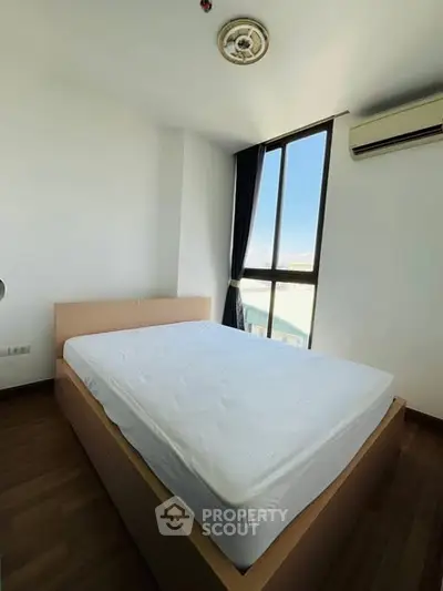 Bright bedroom with large window and modern air conditioning unit