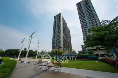 Modern high-rise buildings with lush green garden and benches