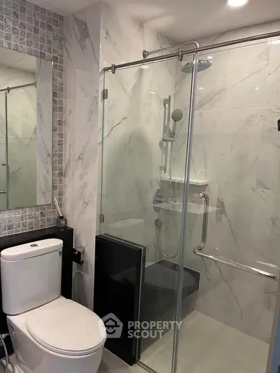 Modern bathroom with glass shower and marble tiles