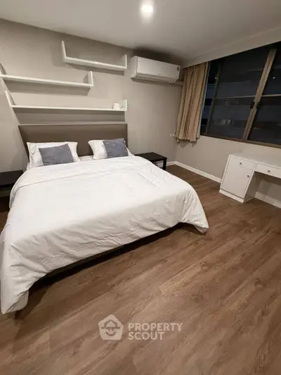 Spacious modern bedroom with elegant decor and large window view