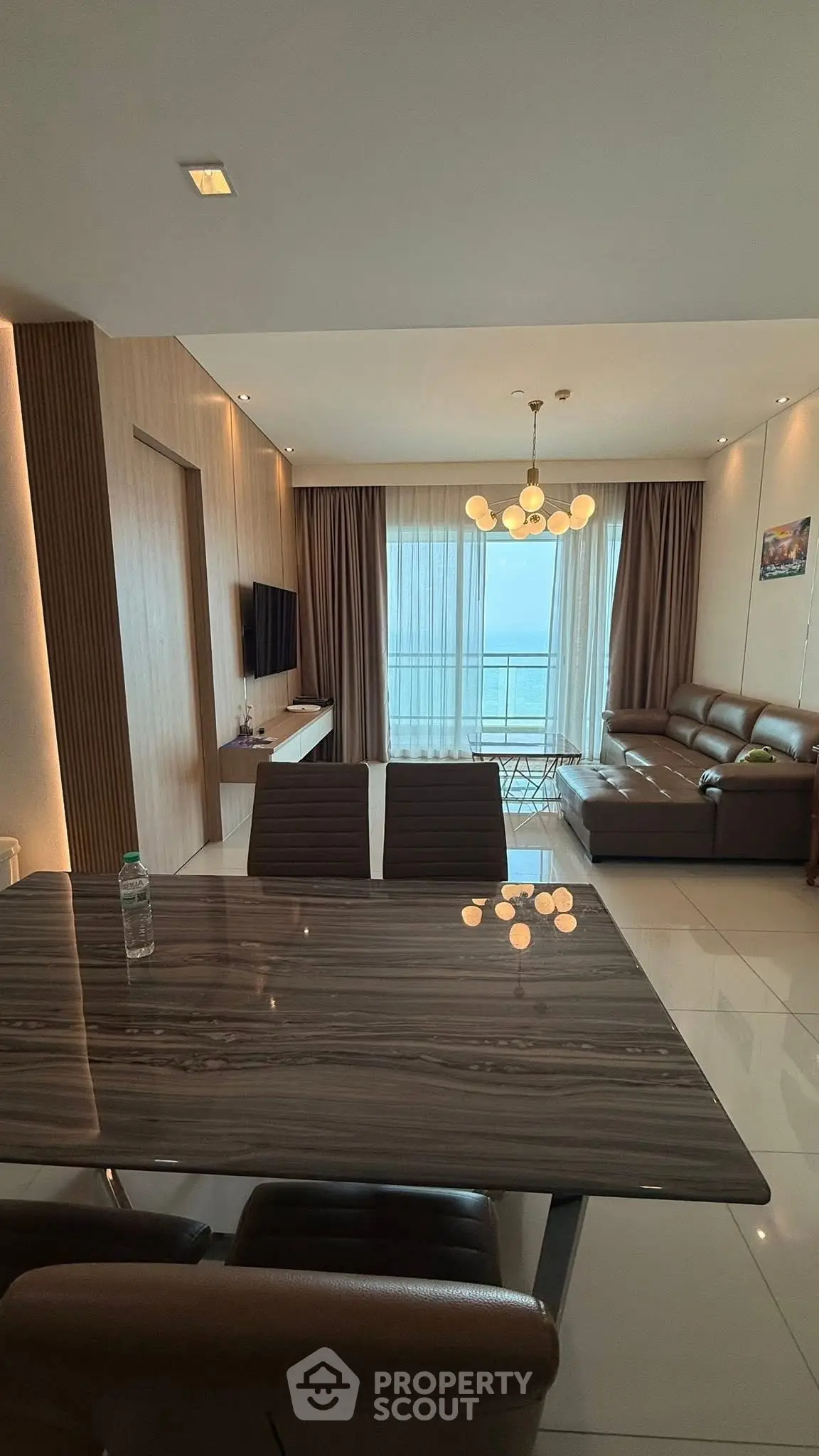 Modern living room with ocean view, elegant furniture, and chic lighting