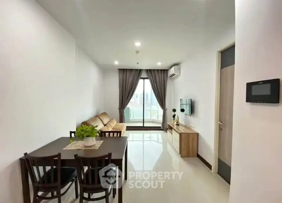 Modern living room with balcony view, stylish furniture, and natural light.