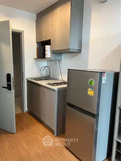 Modern compact kitchen with sleek cabinetry and stainless steel appliances