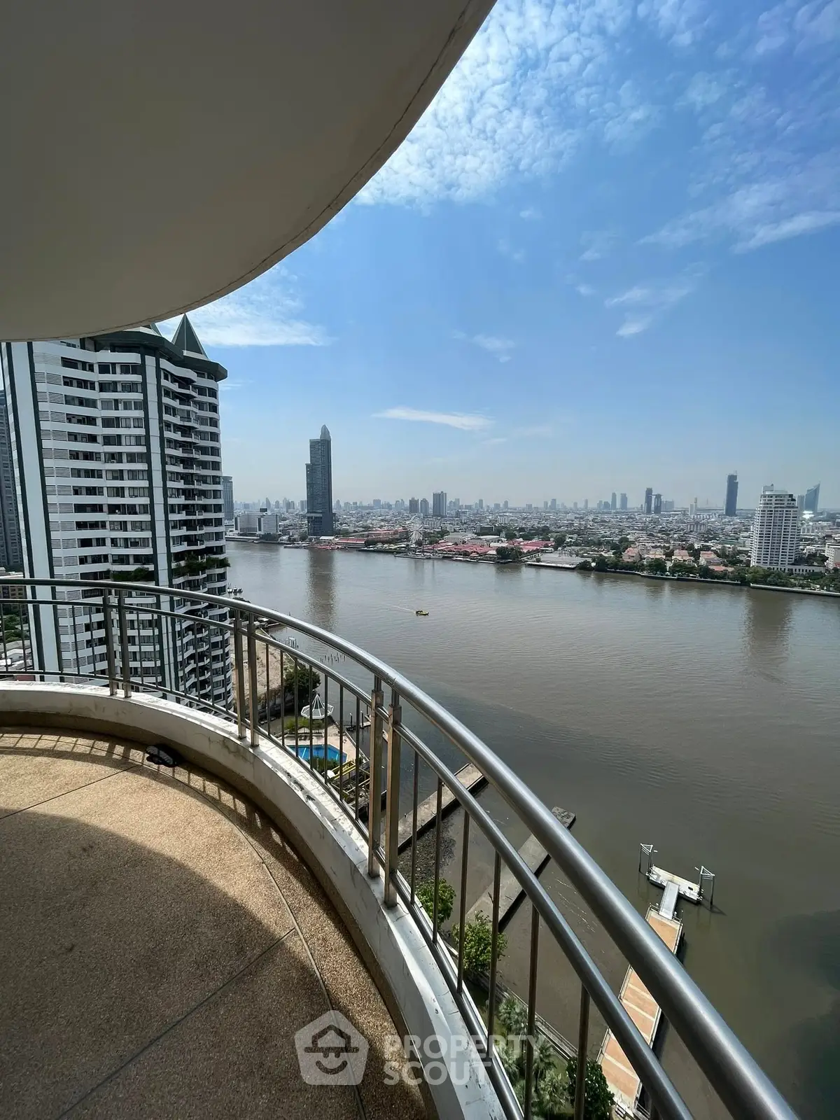 Stunning river view from a high-rise balcony with city skyline in the background.
