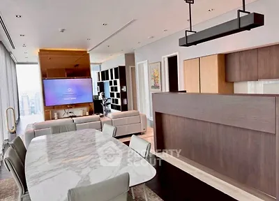 Luxurious open-plan living room with modern kitchen and marble dining table in high-rise apartment.