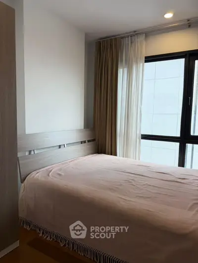 Cozy bedroom with large window and modern decor, perfect for relaxation and comfort.