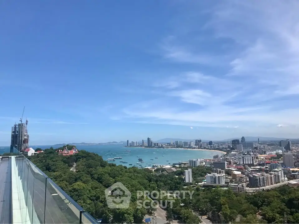 Stunning panoramic view of coastal cityscape with lush greenery and ocean horizon, perfect for luxury living.