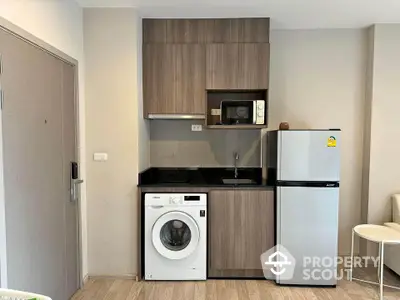 Modern compact kitchen with washing machine and fridge in stylish apartment