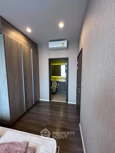 Modern bedroom with ensuite bathroom and sleek wooden flooring