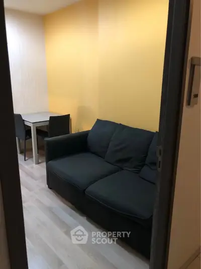 Cozy living room with modern sofa and dining table, perfect for small apartments.
