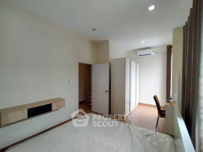 Spacious bedroom with modern design and ample natural light, featuring built-in wardrobe and air conditioning.