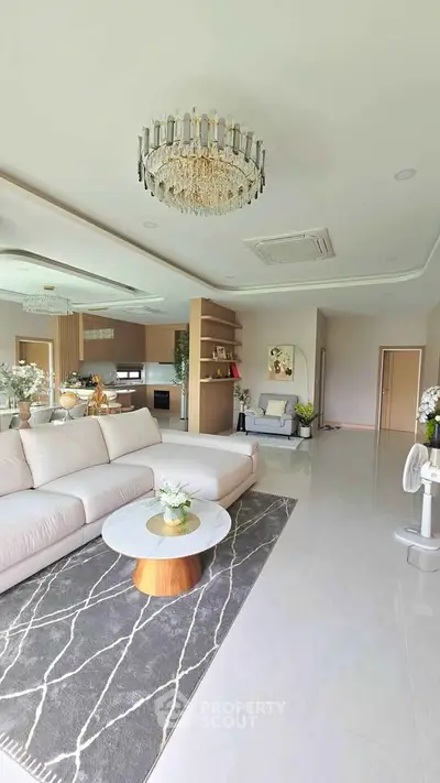 Luxurious open-plan living room with elegant chandelier and modern decor