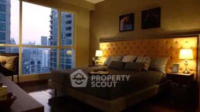 Luxurious bedroom with city view, elegant decor, and ambient lighting in high-rise apartment.