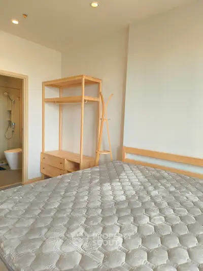 Modern bedroom with minimalist wooden furniture and ensuite bathroom