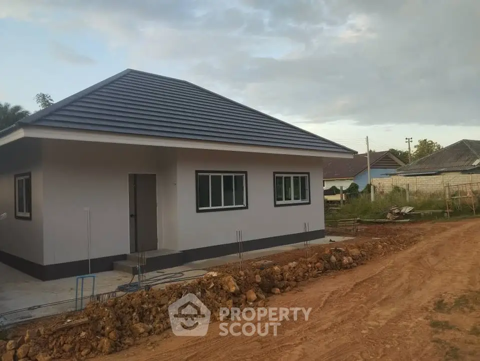 Charming single-story house with modern roof design in a serene neighborhood setting.