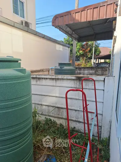 Outdoor area with water tanks and garden space in residential property