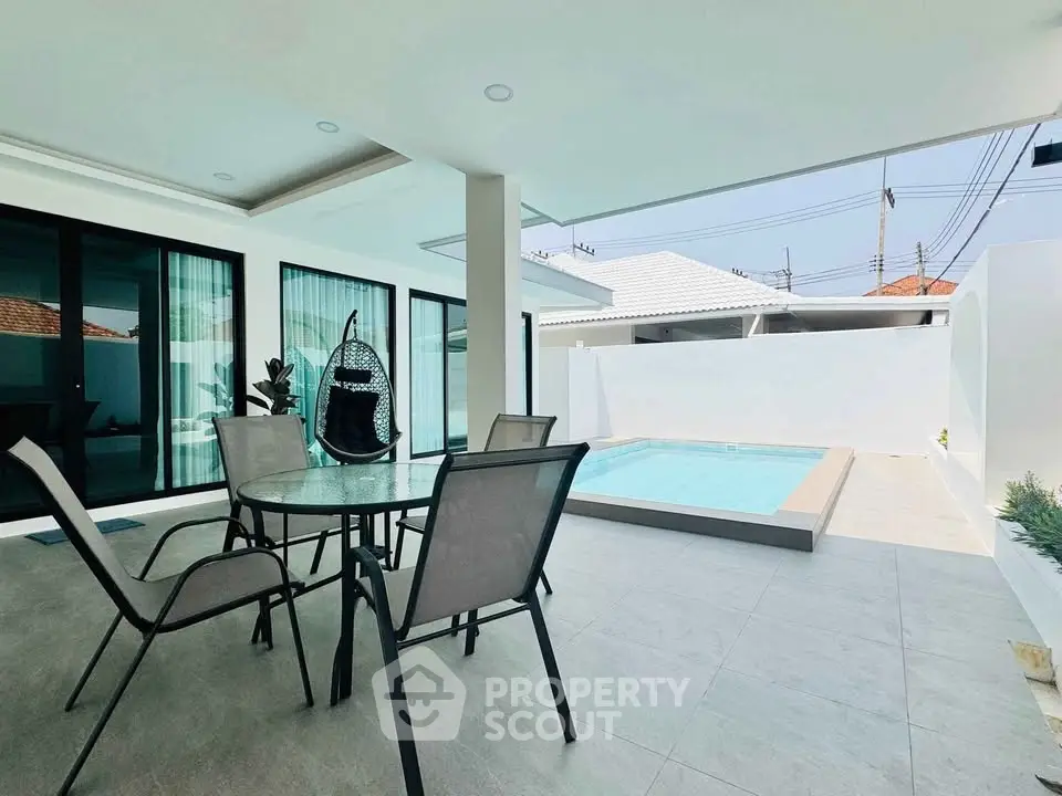 Modern outdoor patio with pool and stylish seating area