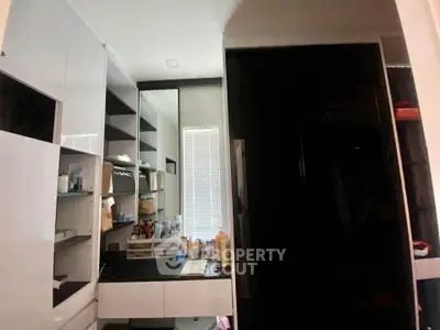 Modern bathroom with sleek black and white cabinetry and ample storage space.