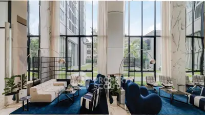 Luxurious modern living room with high ceilings and floor-to-ceiling windows in a stylish apartment building.