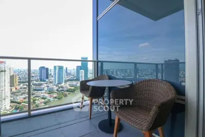 Stunning high-rise balcony with panoramic city view and cozy seating area.