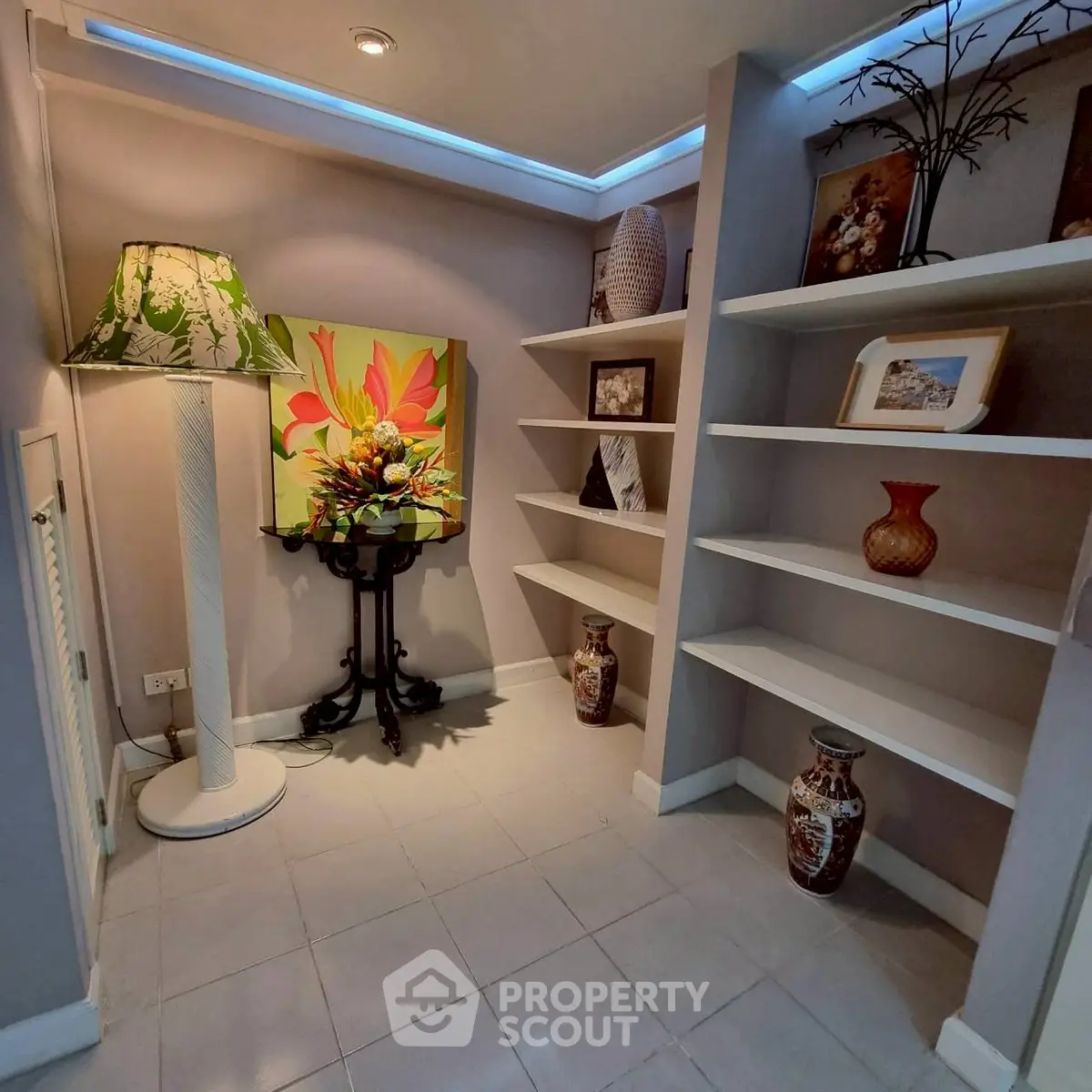 Charming interior nook with elegant decor and built-in shelving, perfect for showcasing art and collectibles.