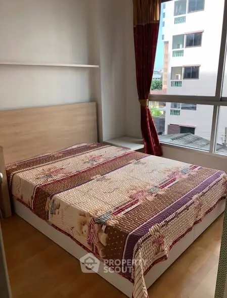 Cozy bedroom with large window and stylish bedding in modern apartment.