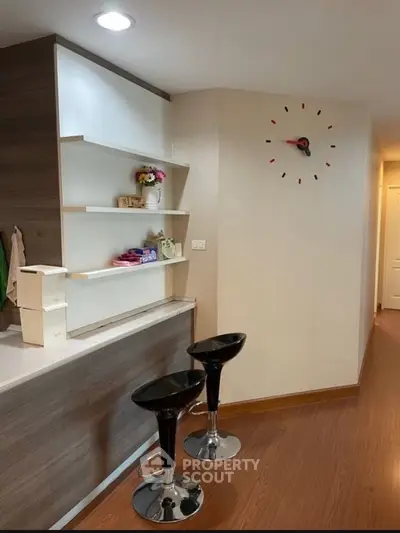 Modern kitchen with stylish bar stools and wall clock