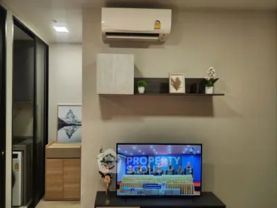 Modern living room with air conditioner and TV, featuring stylish decor and functional design.