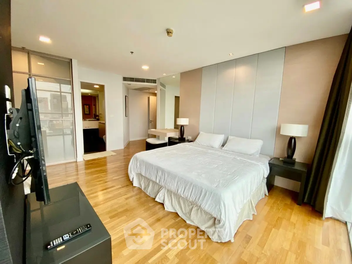 Spacious modern bedroom with hardwood floors and elegant decor