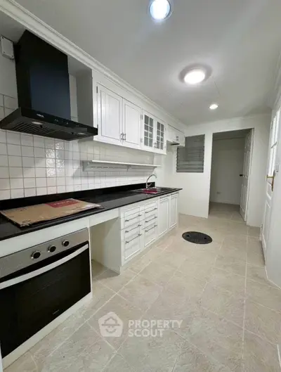 Modern kitchen with sleek white cabinets and built-in oven