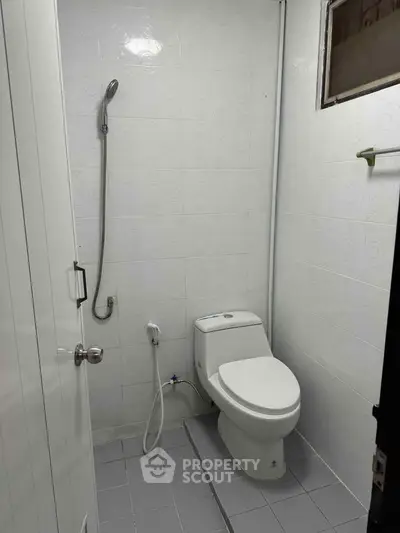 Compact bathroom with shower and toilet, ideal for small spaces.