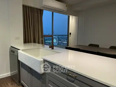 Modern kitchen with city view, featuring sleek countertops and integrated dishwasher.