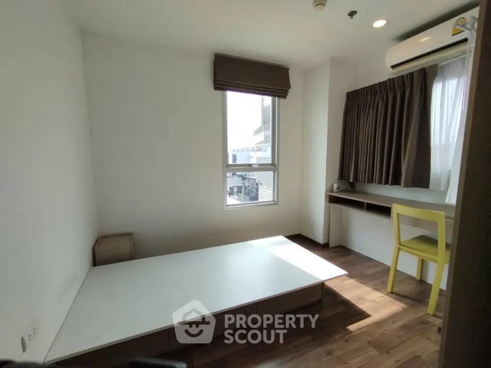 Cozy bedroom with natural light, featuring a minimalist design and wooden flooring, perfect for modern living.