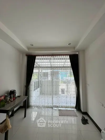 Bright room with large window and sheer curtains, minimalist decor