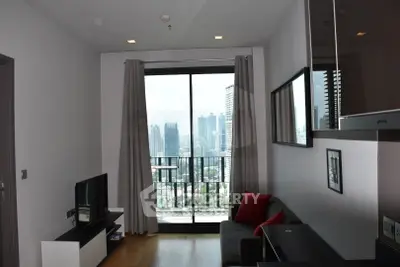 Modern living room with city view and balcony access in high-rise apartment.