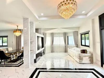 Luxurious open-plan living room with elegant chandelier and marble flooring